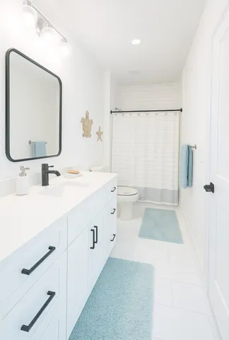 a bathroom with a sink a toilet and a mirror