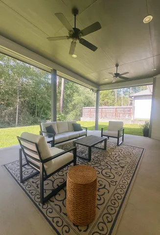 a living room with patio furniture and a large window
