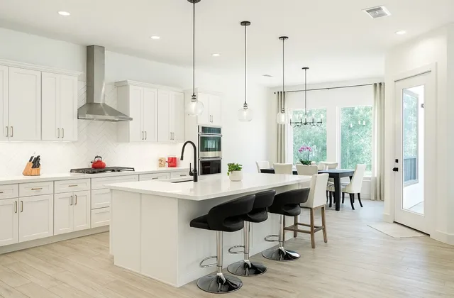 a kitchen with stainless steel appliances kitchen island a large window and white cabinets