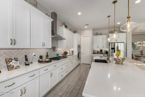 a large kitchen with stainless steel appliances lots of counter space and a sink
