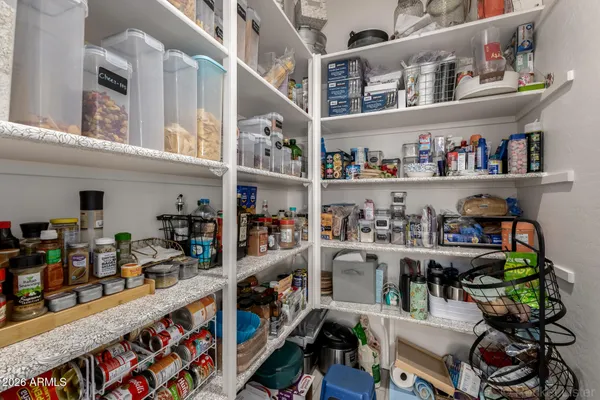 a spacious bedroom with a bed a chandelier and a window