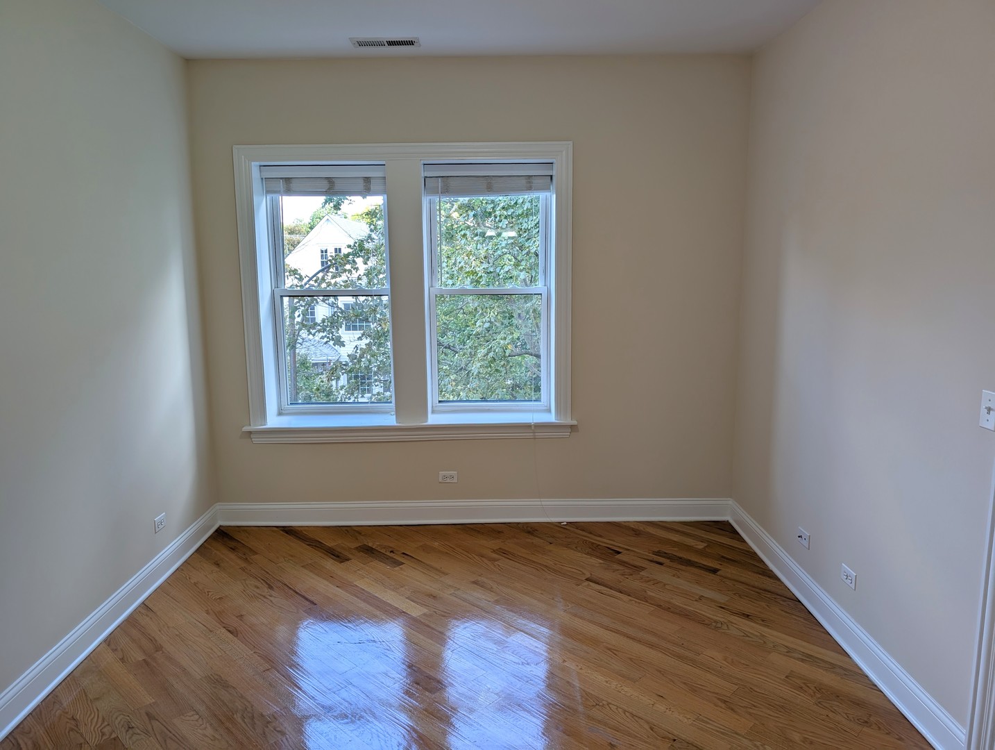 4014 North Central Park Avenue, Unit 3E Chicago, IL 60618 - Photo 6 of 11 an empty room with wooden floor and windows