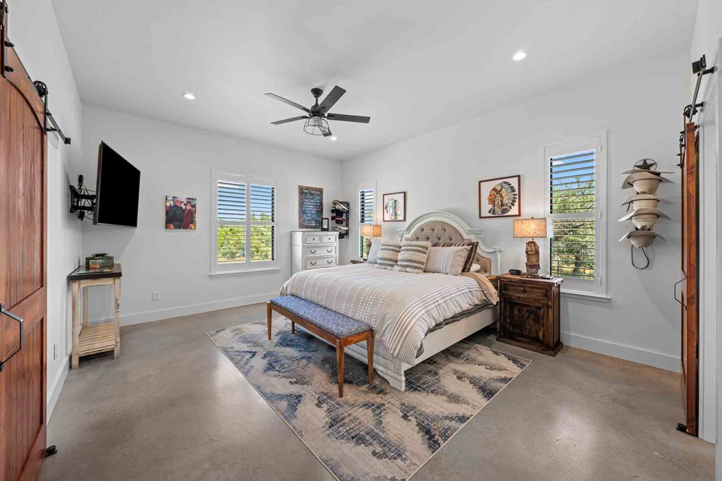 147 Gray Wolf Blanco, TX 78606 - Photo 18 of 34 a bedroom with a bed a flat screen tv and a couch