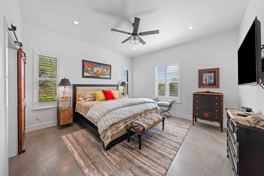 147 Gray Wolf Blanco, TX 78606 - Photo 21 of 34 a spacious bedroom with a bed and a flat screen tv