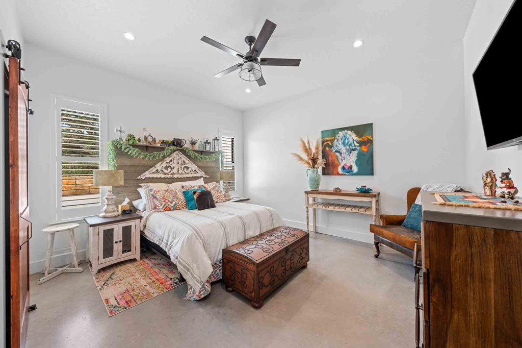 147 Gray Wolf Blanco, TX 78606 - Photo 25 of 34 a spacious bedroom with a bed and a flat screen tv