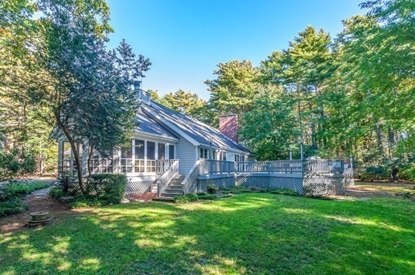a view of a house with backyard and a tree