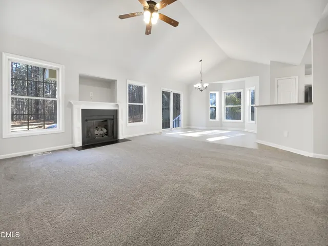a view of a livingroom with a fireplace and chandelier fan