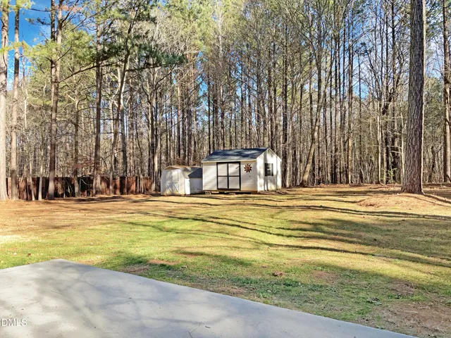 a view of swimming pool in the backyard with large trees