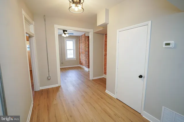 a kitchen with stainless steel appliances granite countertop a refrigerator a sink dishwasher and white cabinets with wooden floor