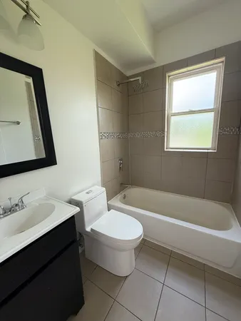 a bathroom with a bathtub a sink a toilet and a mirror