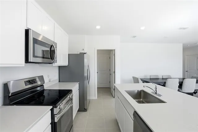 a kitchen that has a sink cabinets counter space and stainless steel appliances