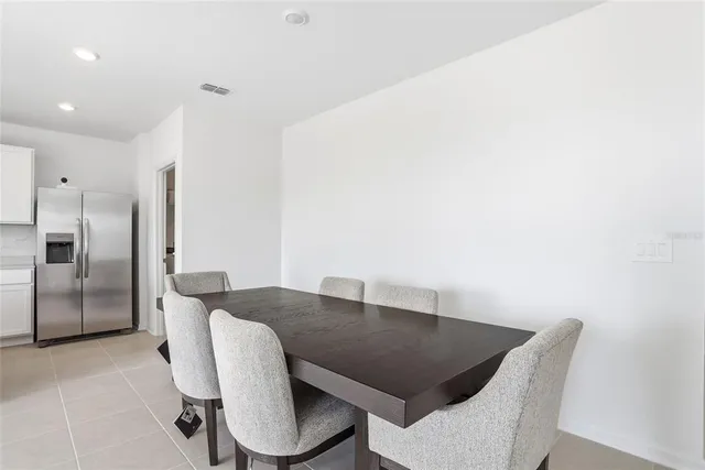 a kitchen with stainless steel appliances a table and chairs