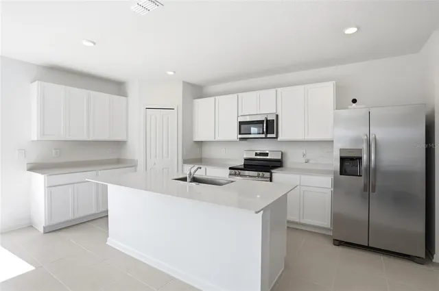 a kitchen with stainless steel appliances granite countertop a refrigerator sink stove microwave and cabinets