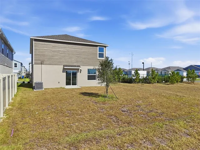 a backyard of a house with plants and wooden fence