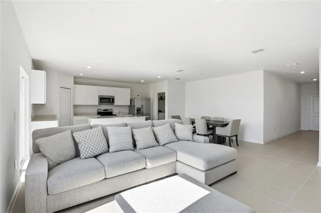 a living room with furniture and view of kitchen