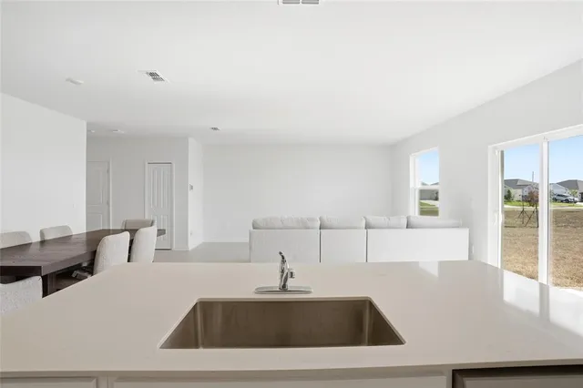a kitchen with a sink a large window and a wooden floor