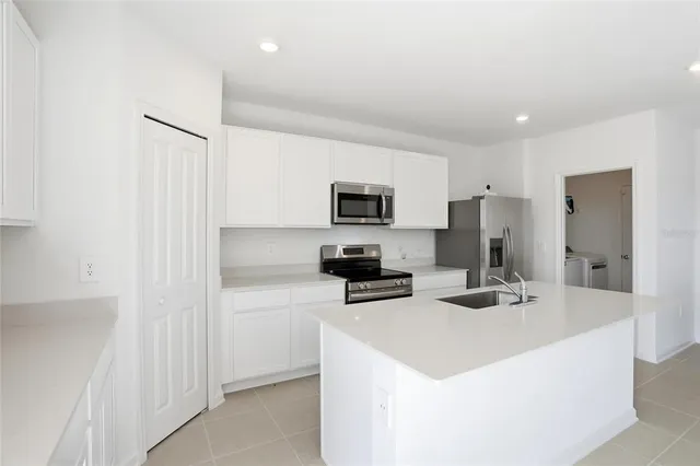 a kitchen with stainless steel appliances a refrigerator sink and microwave