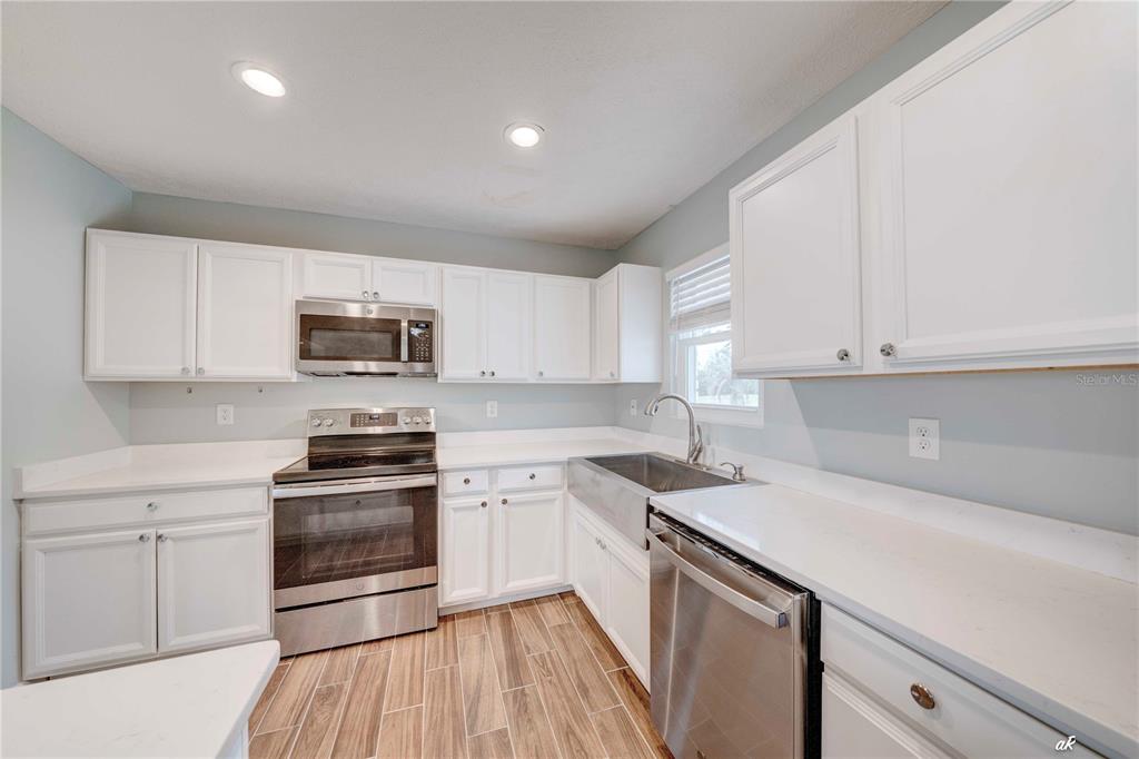 5338 Frank Hough Road Panama City, FL 32404 - Photo 12 of 29 a kitchen with stainless steel appliances a white stove top oven sink and cabinets