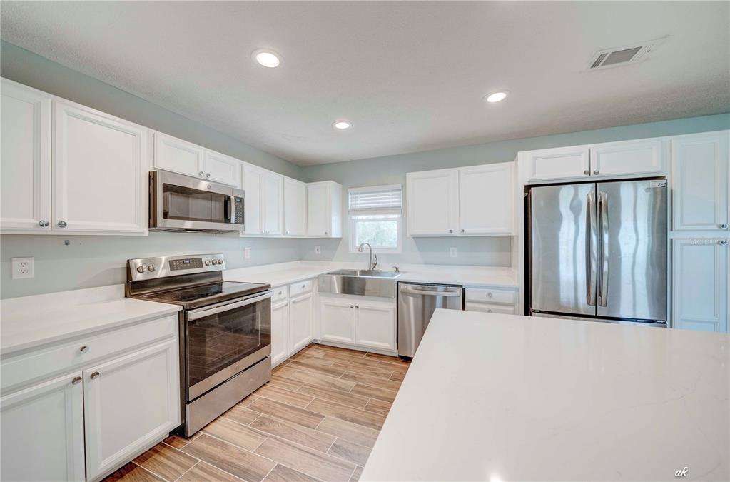 5338 Frank Hough Road Panama City, FL 32404 - Photo 13 of 29 a kitchen with granite countertop a refrigerator stove top oven and sink