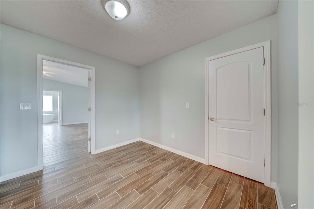 5338 Frank Hough Road Panama City, FL 32404 - Photo 18 of 29 a view of empty room with wooden floor and fan