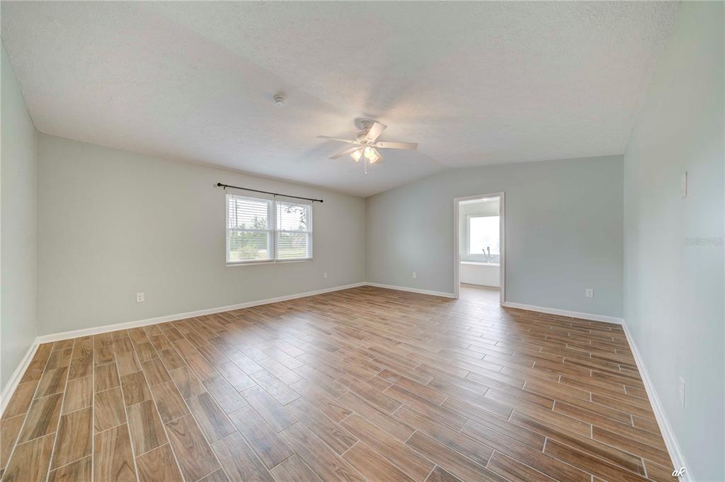 5338 Frank Hough Road Panama City, FL 32404 - Photo 21 of 29 an empty room with wooden floor and windows