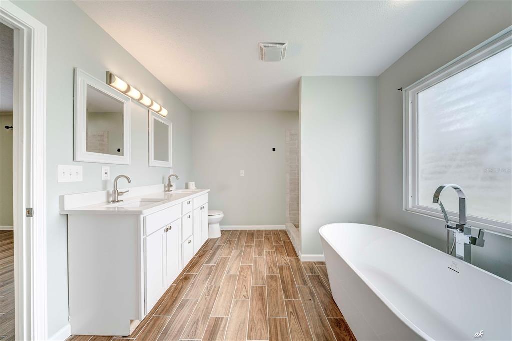 5338 Frank Hough Road Panama City, FL 32404 - Photo 24 of 29 a bathroom with a double vanity sink and a mirror