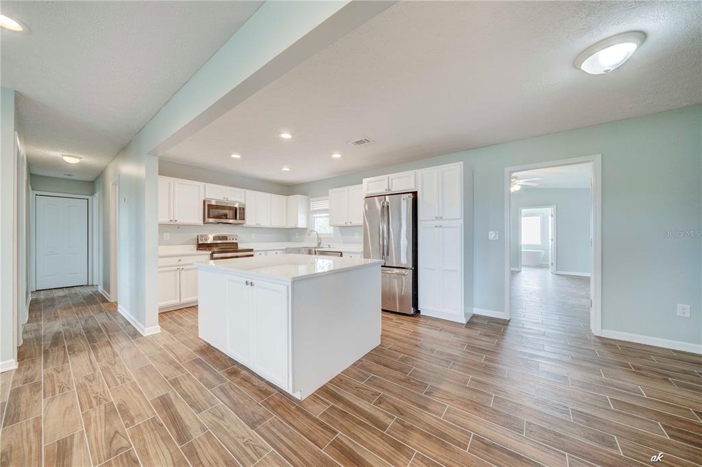 5338 Frank Hough Road Panama City, FL 32404 - Photo 9 of 29 a kitchen with white cabinets and stainless steel appliances