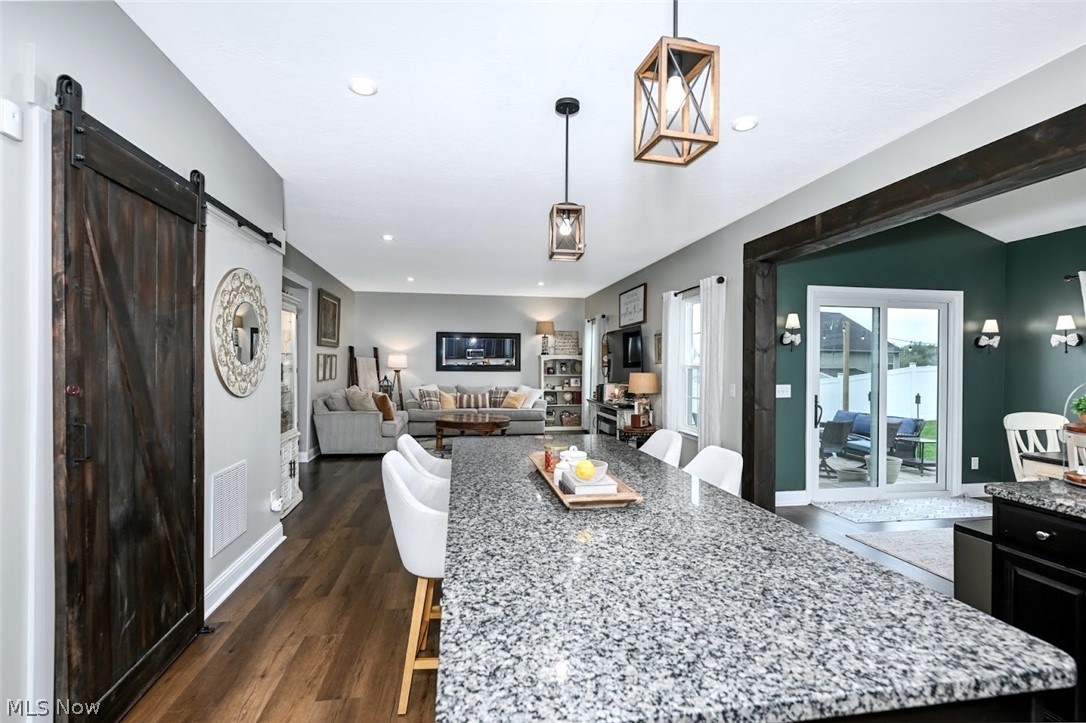 3021 Stonehurst Road Uniontown, OH 44685 - Photo 13 of 48 *EXQUISITE EAT IN KITCHEN W/OVER 8 FT. ISLAND, CUSTOM BARN DOOR FOR PANTRY, DUAL CAGED PENDANT LIGHTING, GRANITE COUNTERTOPS, TALLER BLACK CABINETS, TILE BACKPLASH, RAISED BREAKFAST BAR & MORE! ~