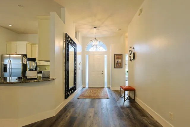 a view of a hallway with wooden floor windows and livingroom