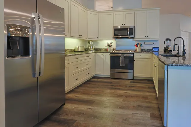 a kitchen with cabinets stainless steel appliances and a window