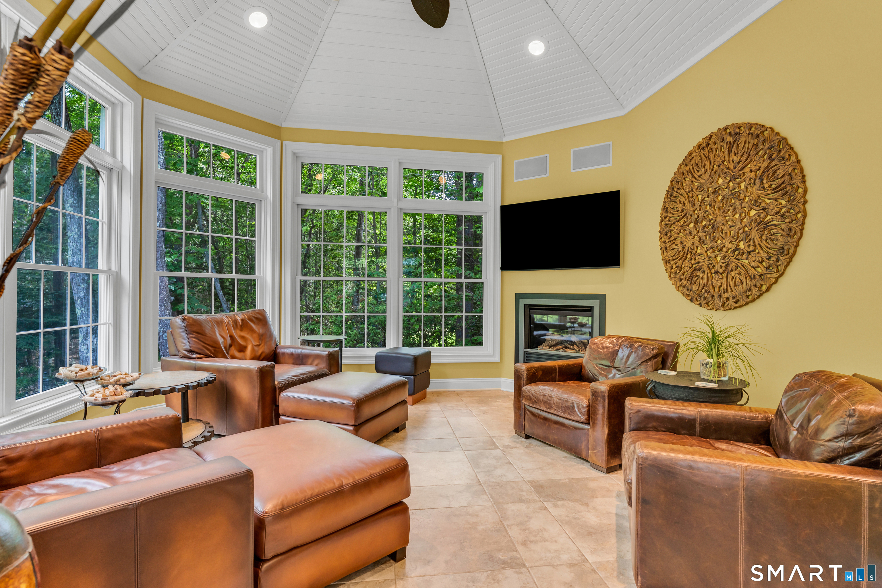 11 Timber Lane Guilford, CT 06437 - Photo 16 of 39 This end of the Sunroom is set up with walls of windows, gas fireplace and can have door added if preferred. Includes built-in air filtration system perfect for "cigar lounge" fun.