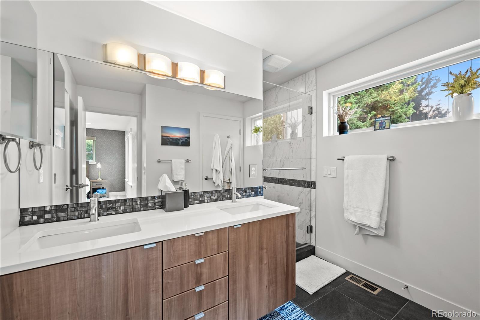 3448 West 36th Avenue Denver, CO 80211 - Photo 22 of 48 a bathroom with a double vanity sink a mirror and a bathtub