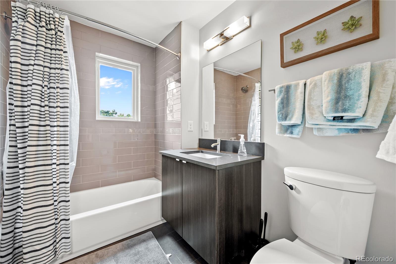 3448 West 36th Avenue Denver, CO 80211 - Photo 24 of 48 a bathroom with a granite countertop toilet sink and mirror