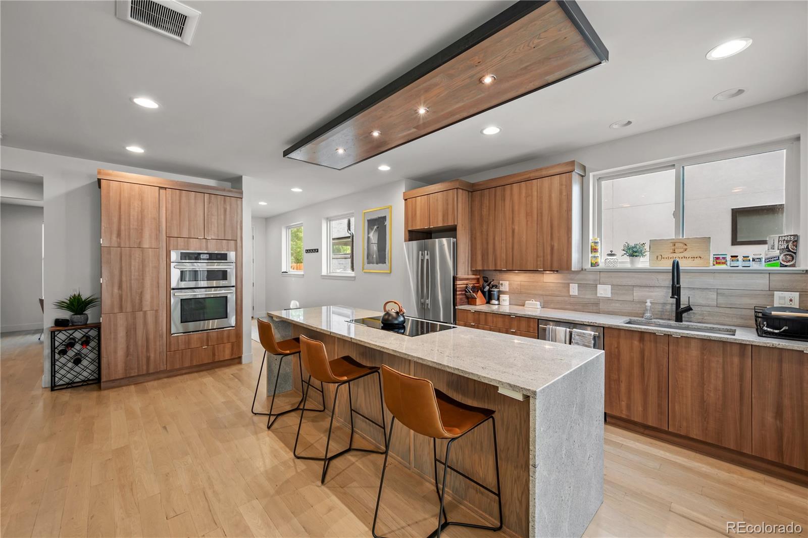 3448 West 36th Avenue Denver, CO 80211 - Photo 9 of 48 a kitchen with stainless steel appliances granite countertop a table chairs sink refrigerator and cabinets
