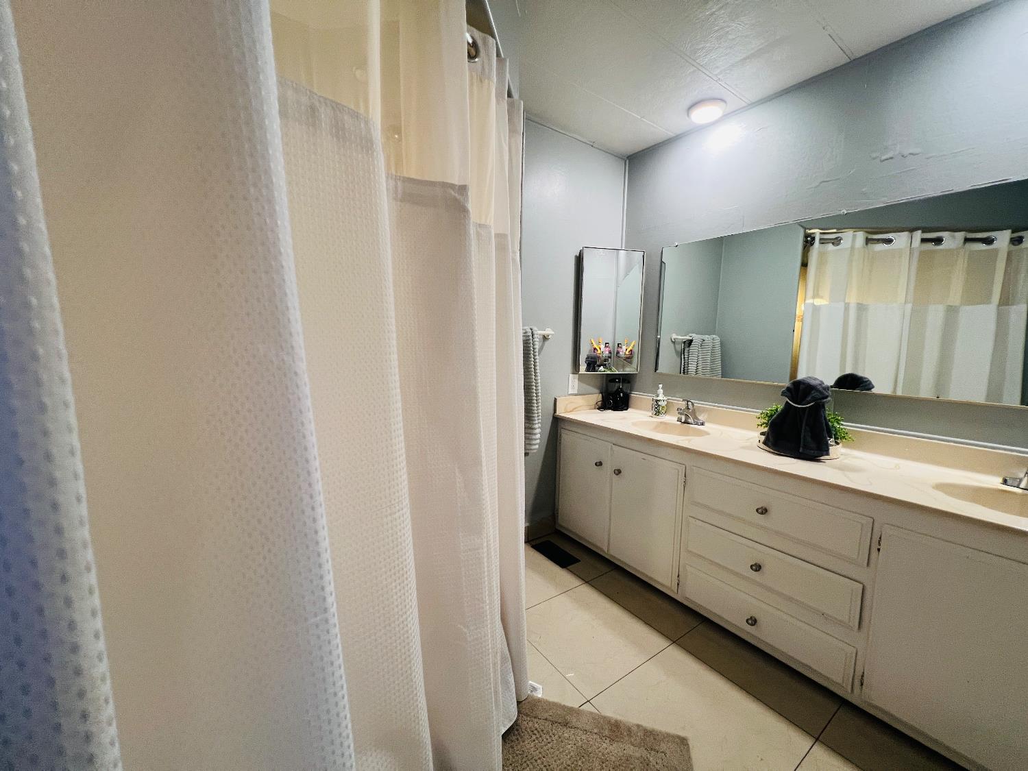 2845 East E Hatch Road, Unit 86 Ceres, CA 95351 - Photo 25 of 32 a bathroom with a double vanity sink and mirror