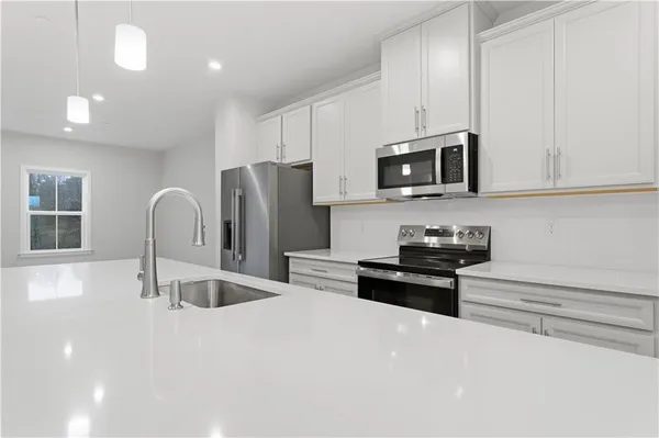 a kitchen with granite countertop a refrigerator stove and microwave