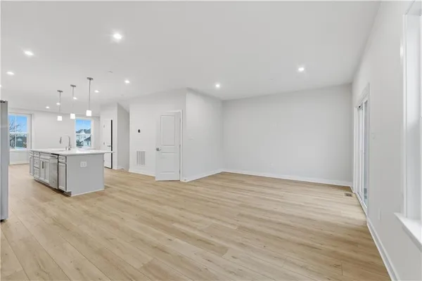 a view of kitchen with kitchen island white cabinets and wooden floor