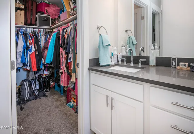 a view of walk in closet with clothes