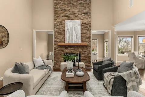 a living room with furniture kitchen view and a chandelier