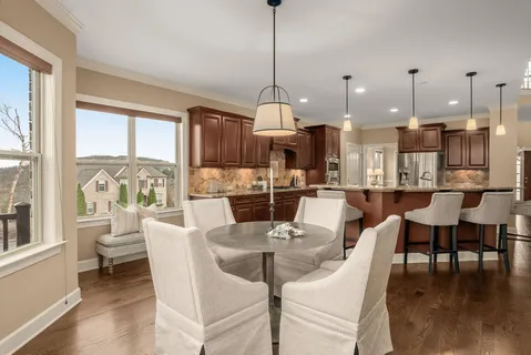 a kitchen with stainless steel appliances granite countertop a kitchen island a table and chairs