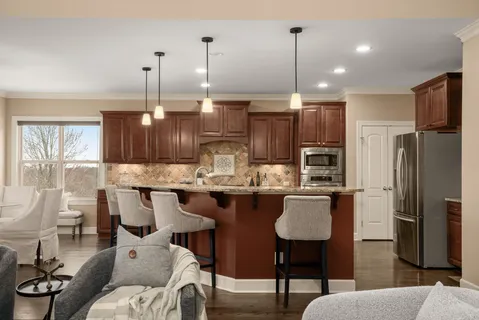 a kitchen with stainless steel appliances granite countertop a stove a sink and a wooden floors