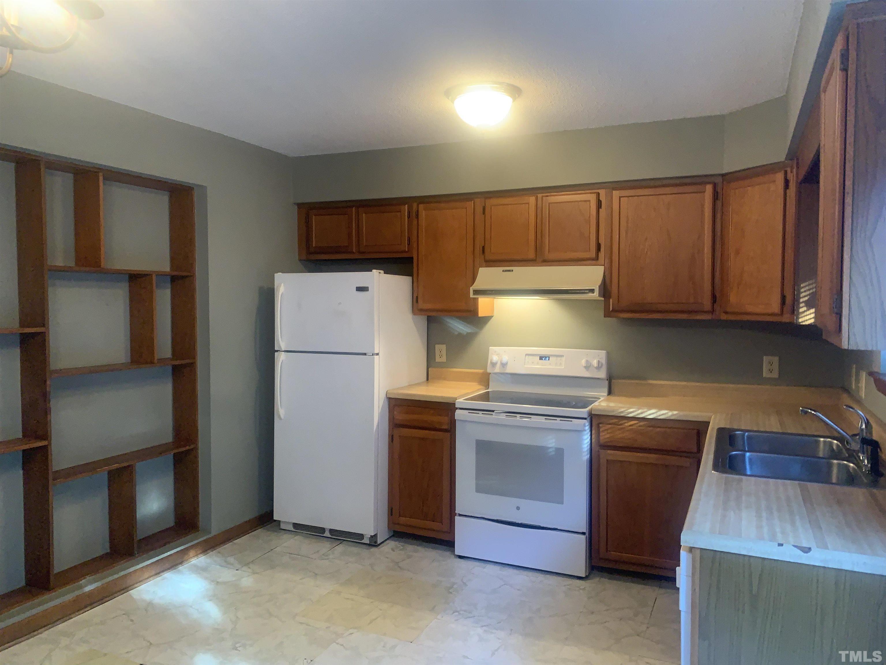 5852 Shady Grove Circle Raleigh, NC 27609 - Photo 4 of 13 a kitchen with a refrigerator sink and cabinets