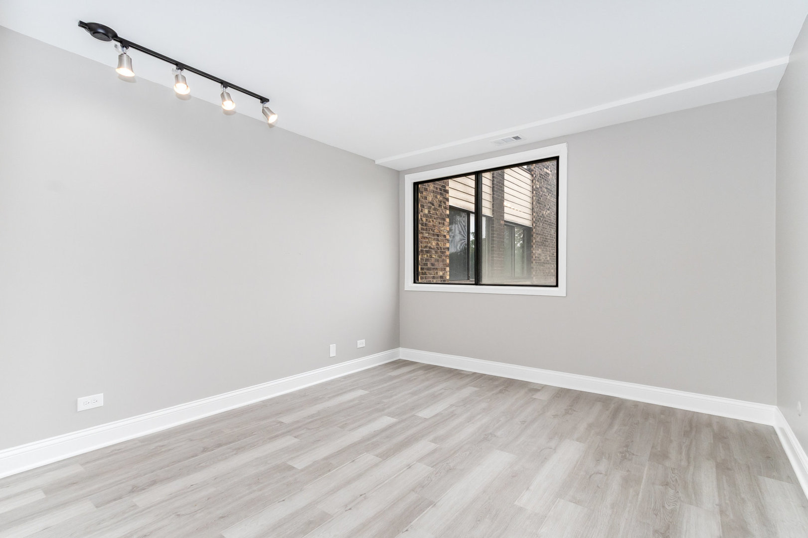 470 Raintree Court, Unit 2H Glen Ellyn, IL 60137 - Photo 18 of 22 a view of an empty room with wooden floor and a window