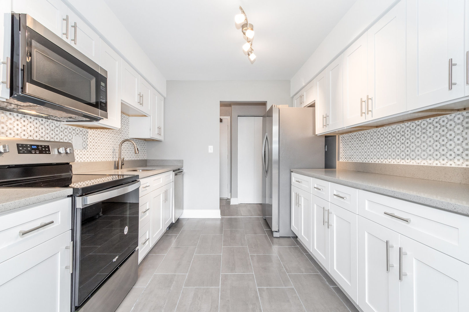 470 Raintree Court, Unit 2H Glen Ellyn, IL 60137 - Photo 2 of 22 a kitchen with stainless steel appliances granite countertop a stove top oven a sink dishwasher and a refrigerator with wooden cabinets