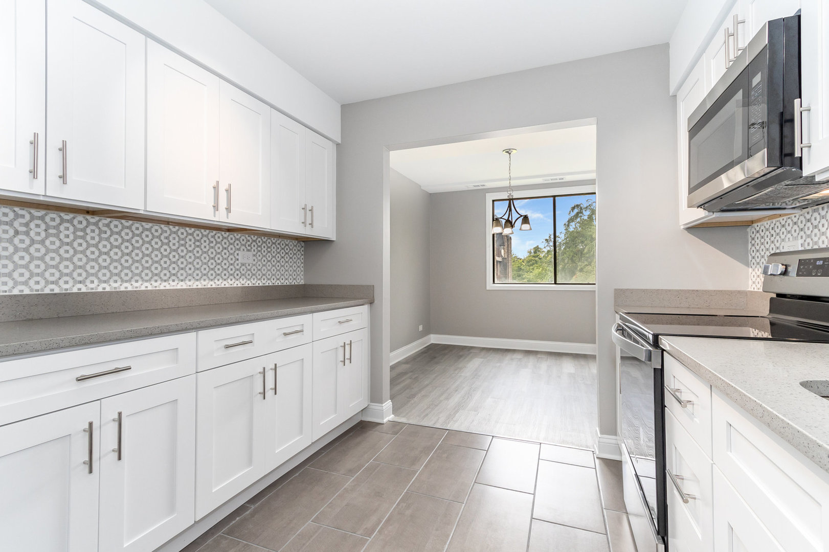 470 Raintree Court, Unit 2H Glen Ellyn, IL 60137 - Photo 3 of 22 a kitchen with granite countertop white cabinets and white appliances