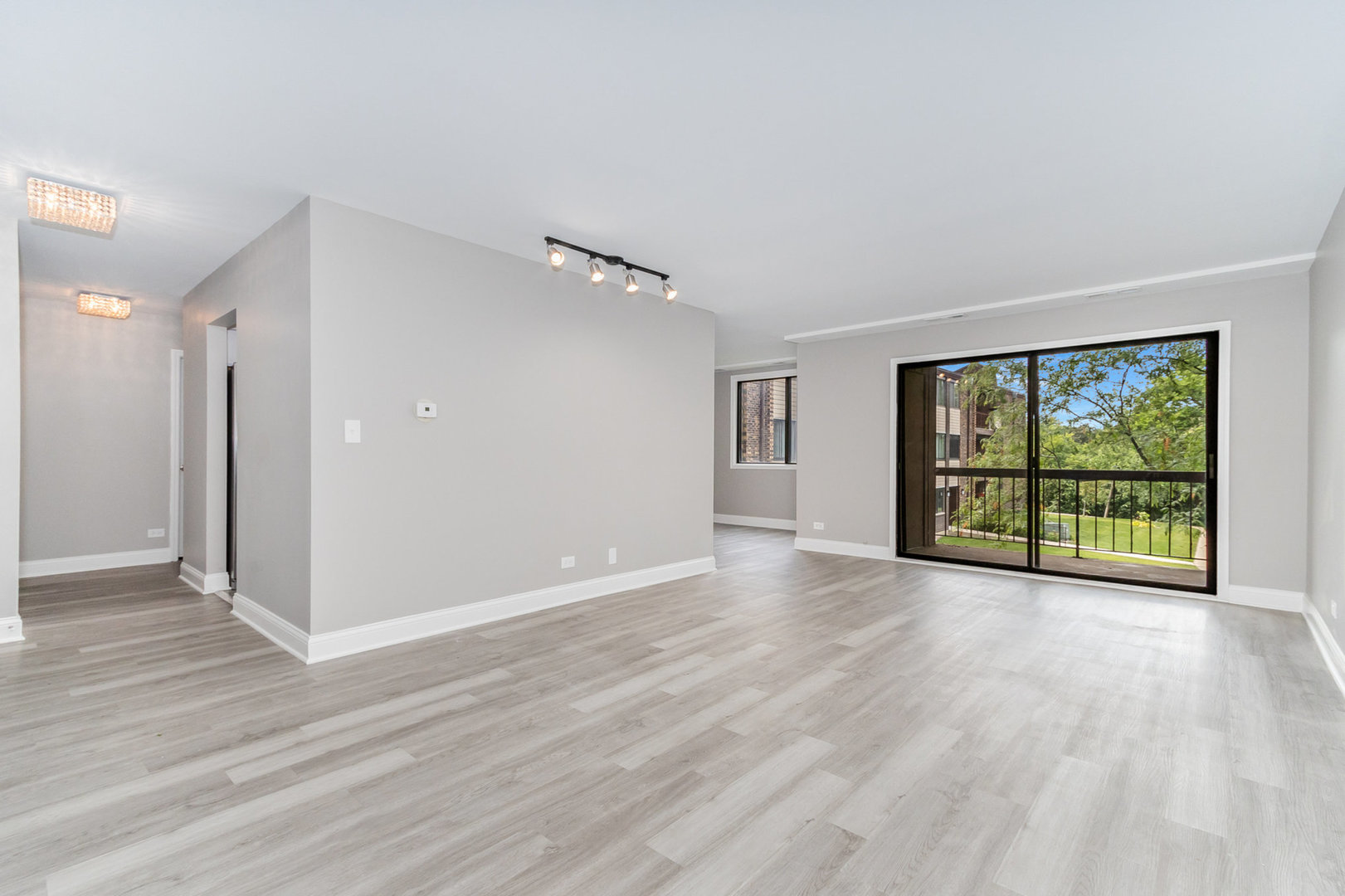 470 Raintree Court, Unit 2H Glen Ellyn, IL 60137 - Photo 7 of 22 a view of an empty room with wooden floor and a window