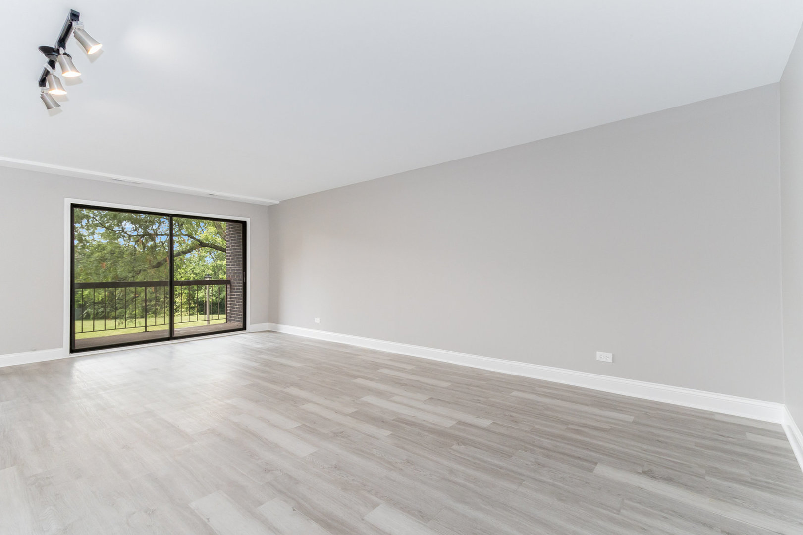 470 Raintree Court, Unit 2H Glen Ellyn, IL 60137 - Photo 9 of 22 a view of an empty room with wooden floor and a window