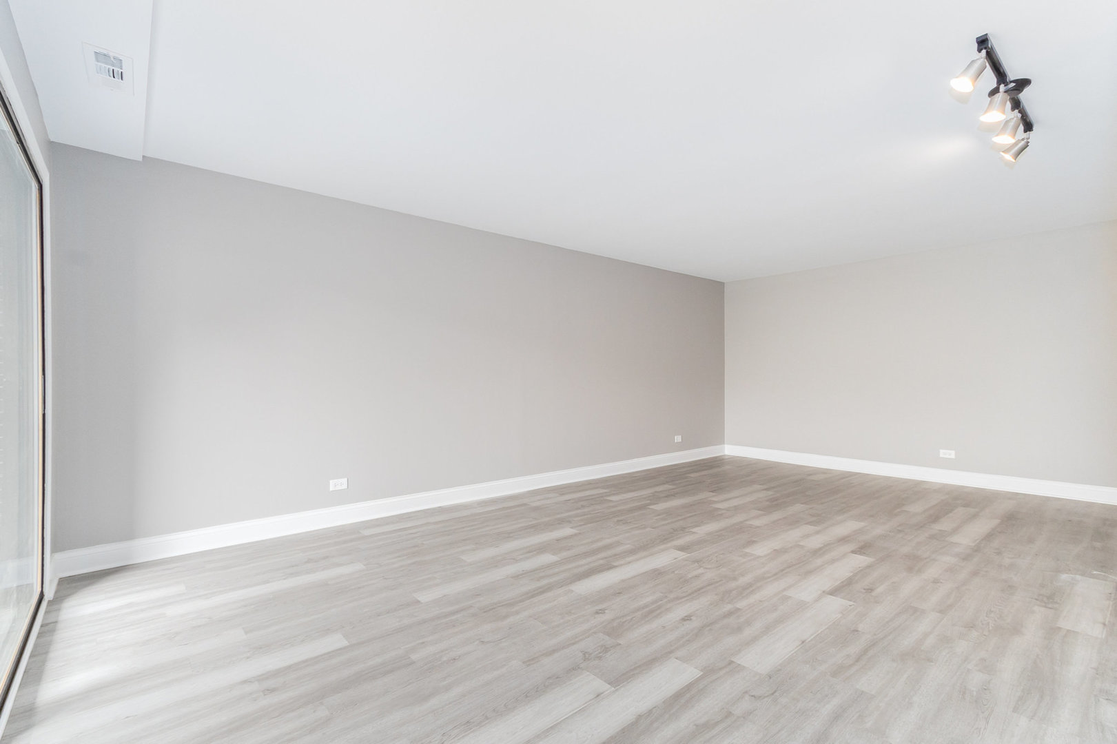 470 Raintree Court, Unit 2H Glen Ellyn, IL 60137 - Photo 10 of 22 a view of an empty room with wooden floor and a window