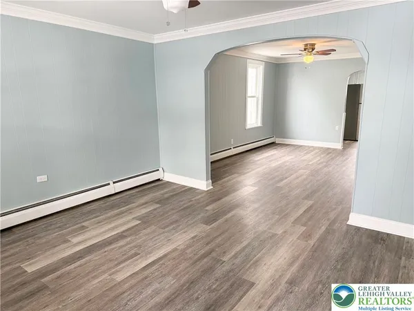 an empty room with wooden floor and mirror