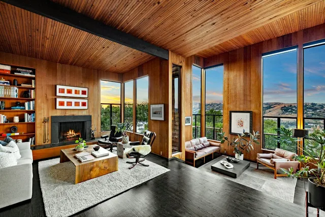 a living room with furniture a fireplace and floor to ceiling window